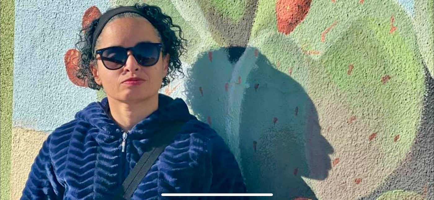 Puerto Rican woman against a painted wall, casting a visually complex shadow